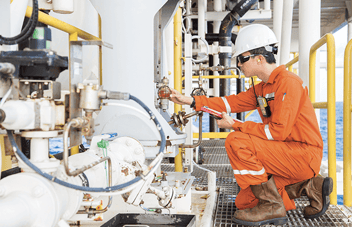 A worker checking industrial equipment