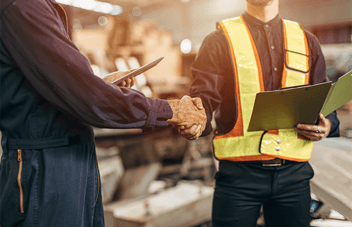 Two industrial workers shaking hands