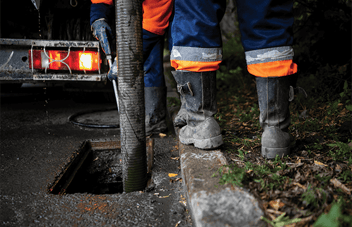 Worker jetting a sewer with industrial pump