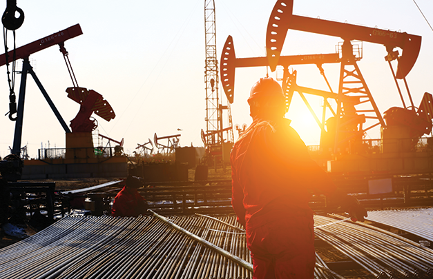 Man standing in front of an oil & gas production facility